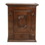 A Late 17th Century Oak Wall Cupboard, the hinged cupboard door with a geometric moulded panel