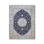 Nain Carpet Central Iran, circa 1970The indigo field of vines around a flowerhead medallion framed