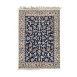 Nain RugCentral Iran, circa 1970The indigo field of vines and palmettes enclosed by ivory borders of