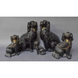 Two Pairs of Black Glazed Staffordshire Seated Spaniels, with gilt painted collars, and A Single