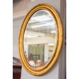 A 19th Century Gilt Framed Mirror, the bevelled oval plate within a conforming reeded frame, 61cm by