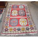 An Anatolian Rug, the crimson field with six octagons enclosed by hooked motif borders, 184cm by