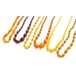 Six Amber/Amber Type Necklaces, of varying designs and lengthsThe pieces are in fair condition