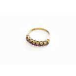 A 9 Carat Gold Ruby Seven Stone Ring, finger size MGross weight 2.5 grams.