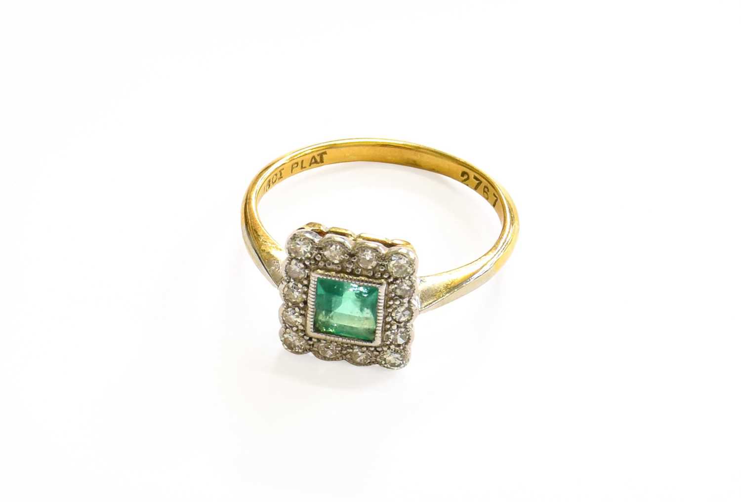 An Emerald and Diamond Cluster Ring, the square step cut emerald within a border of eight-cut