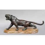 A Japanese Meiji Period Bronze Figure of a Stalking Tiger, on a wooden plinth, 32cm long Missing one