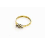 An 18 Carat Gold Diamond Three Stone Ring, the graduated round brilliant cut diamonds, in white claw