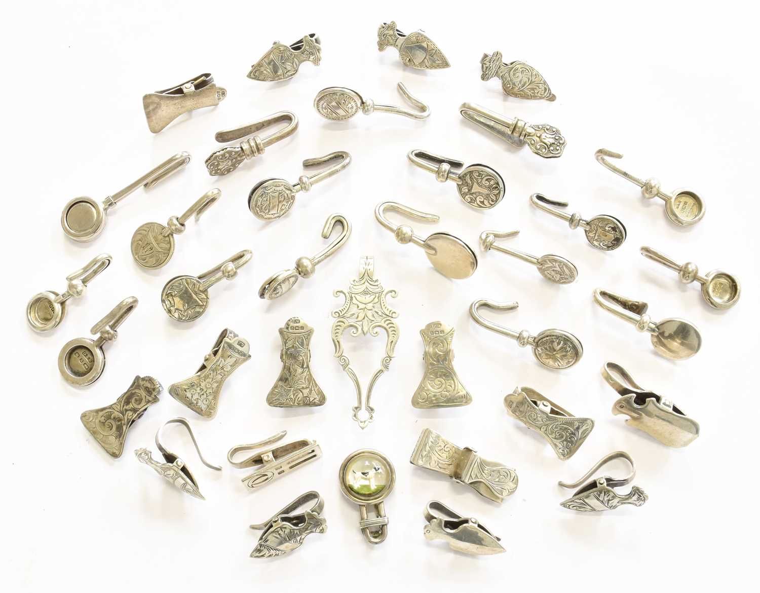 A Collection of Silver and White Metal Napkin Clips, one set with an Essex crystal of a Jack Russell