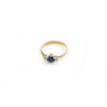 An 18 Carat Gold Sapphire and Diamond Three Stone Ring, the oval cut sapphire flanked by round