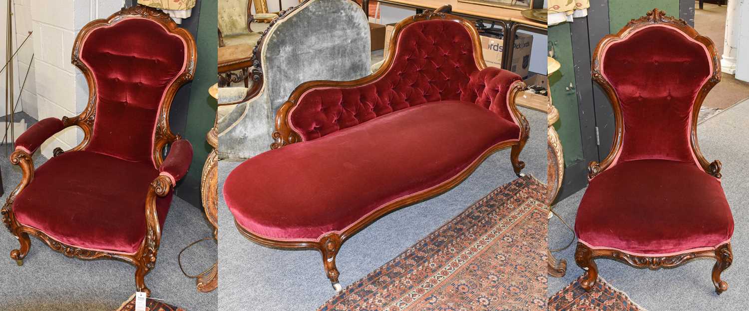 A Victorian Button Back Gents Open Armchair, with carved walnut frame decorated with scrolling