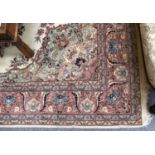 An Turkish Carpet, the ivory ground, the central medallion enclosed by floral vine borders, 309cm by