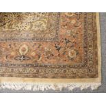 A Large Indian Carpet, with an Ivory field of scrolling indigo vines centered by a small