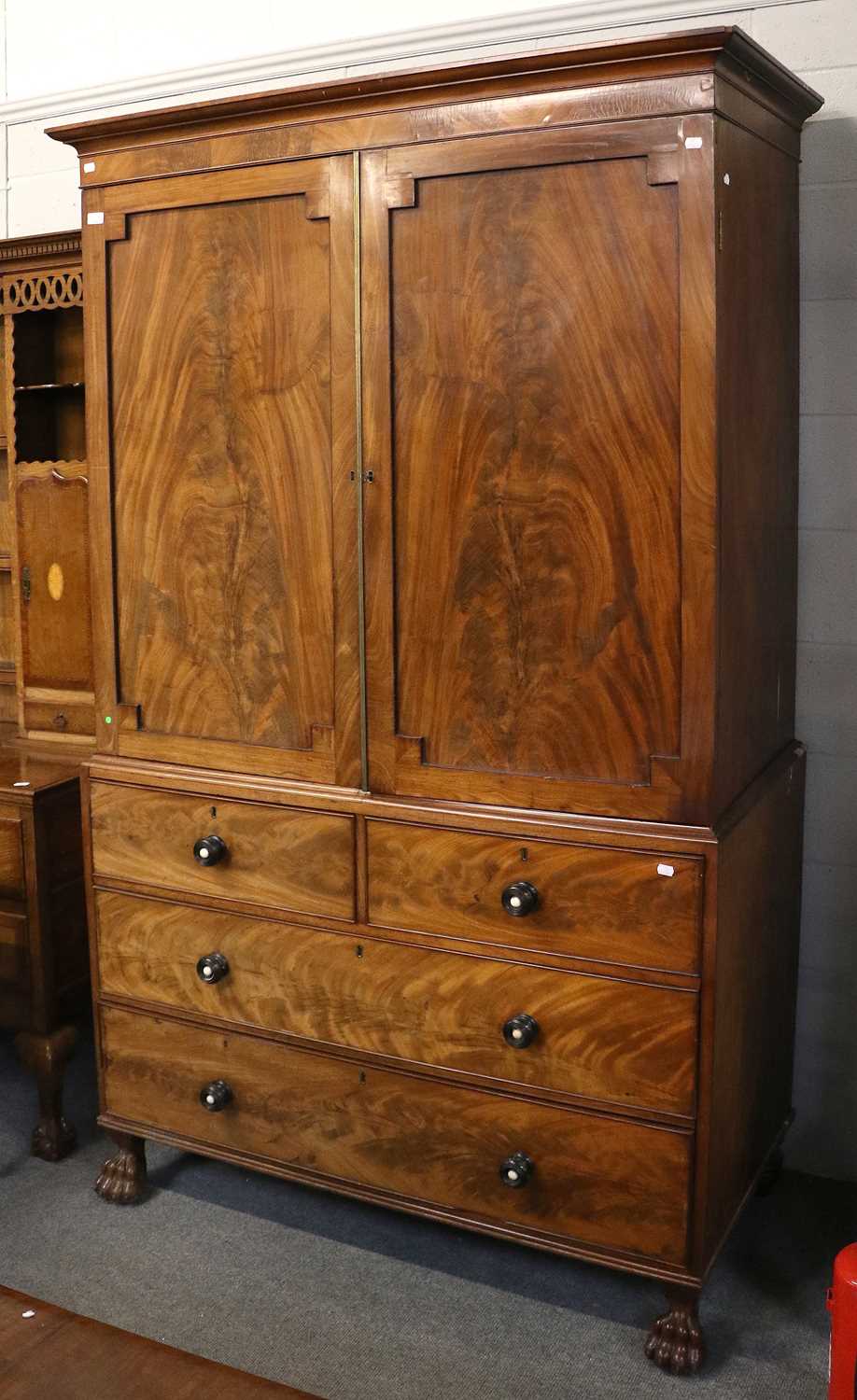 A George III Mahogany Press Cupboard, fitted for hanging with turned ebonised and handles on paw