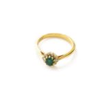 An 18 Carat Gold Emerald and Diamond Cluster Ring, the oval cut emerald within a border of round