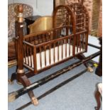 An Empire Style Parcel-Gilt Mahogany Cradle, the cradle with turned spindle construction,