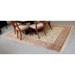 Indian Rug, the camel ground of vines enclosed by salmon pink borders, 296cm by 192cm