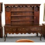 A George III Oak Dresser and Rack, 198cm by 50cm 200cmBrassware replaced. Upper section cupboards
