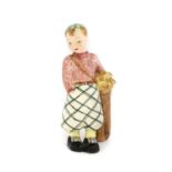 A Staffordshire Goldscheider Figure of a Boy Golf Caddy, circa 1940s, wearing check trousers, pink