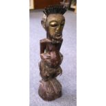 A West African Carned Harwood Tribal Statue, adorned with tooled brass and vegetable stands, 62cm