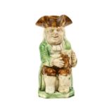 A Ralph Wood Type Creamware Toby Jug, circa 1790, of traditional form, the seated figure holding a