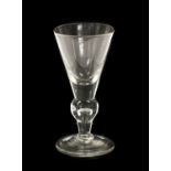 A Heavy Baluster Wine Glass, circa 1710, the conical bowl with solid base on an inverted baluster