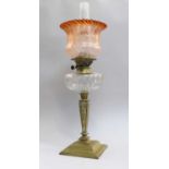 A Late Victorian/Edwardian Brass Oil Lamp, with cut glass reservoir and apricot glass shadeSome