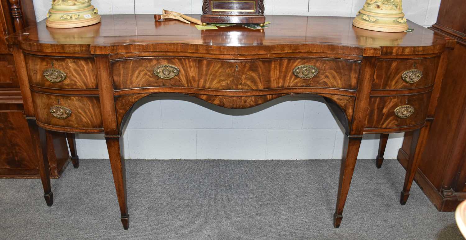 A George III Mahogany Serpentine Sideboard, cross banded and strung, with cockbeading and square