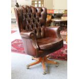 Canella: A Reproduction Executive Swivel Armchair, covered in close-nailed brown buttoned leather,