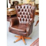 Canella: A Reproduction Executive Swivel Armchair, covered in close-nailed brown buttoned leather,