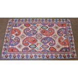 Kashmir Chain Stitch Rug, the brick red field richly decorated with flowers around a floral panel