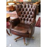 Canella: A Reproduction Executive Swivel Armchair, covered in close-nailed brown buttoned leather,