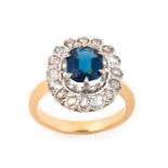 A Sapphire and Diamond Cluster Ringthe oval cut sapphire within a border of rose cut diamonds, in