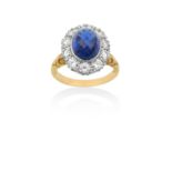 An 18 Carat Gold Sapphire and Diamond Cluster Ringthe faceted oval cabochon sapphire in a white