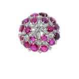 A Ruby and Diamond Cluster Ringthe central round brilliant cut diamond within a border of baguette