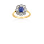 A Sapphire and Diamond Cluster Ringthe cushion shaped sapphire in a white millegrain setting, within