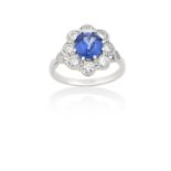 A Sapphire and Diamond Cluster Ringthe round cut sapphire within a border of round brilliant cut