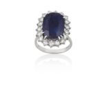 An 18 Carat White Gold Sapphire and Diamond Cluster Ringthe oval cut sapphire within a border of