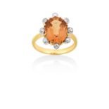 A Topaz and Diamond Cluster Ringthe oval cut topaz in a yellow claw setting, within a border of