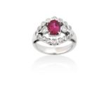 A Ruby and Diamond Cluster Ringthe oval cut ruby in a white claw setting, flanked by round brilliant
