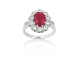 A Ruby and Diamond Cluster Ringthe oval cut ruby within a border of round brilliant cut diamonds, in
