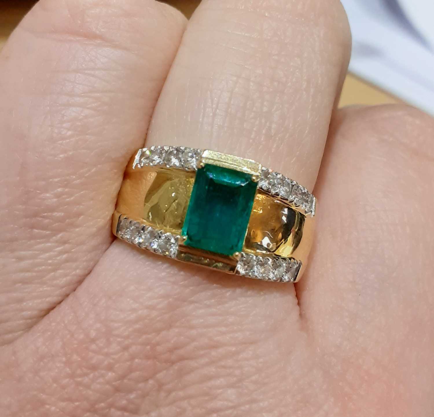 An 18 Carat Gold Emerald and Diamond Ringthe emerald-cut emerald in a yellow claw setting, to a - Image 2 of 4