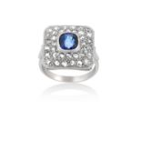 A Sapphire and Diamond Cluster Ringthe square plaque with a cushion cut sapphire in a white rubbed