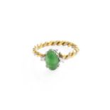 An 18 Carat Two Colour Gold Jade and Diamond Ring, the oval cabochon jade flanked by two round