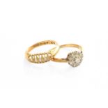 An 18 Carat Gold Diamond Cluster Ring, the central raised round brilliant cut diamond within a