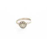 A Diamond Cluster Ring, the central raised round brilliant cut diamond within a border of eight-
