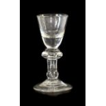 A Dram Glass, circa 1720, the rounded funnel bowl with solid base on an annular knop, plain stem