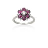 A Pinkish-Red Stone and Diamond Cluster Ringthe round brilliant cut diamond within a border of