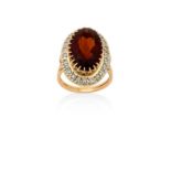 A Citrine and Diamond Cluster Ringthe central raised oval cut citrine in yellow claw settings,
