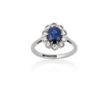 A Sapphire and Diamond Cluster Ringthe oval cut sapphire within a border of round brilliant cut