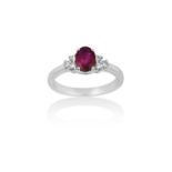 An 18 Carat White Gold Synthetic Ruby and Diamond Ringthe oval cut synthetic ruby flanked by trios